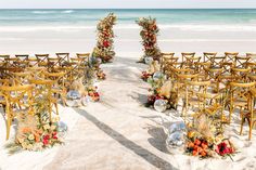 an outdoor ceremony set up on the beach with chairs and flowers in front of the ocean