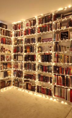 a room filled with lots of books and lights on the wall next to each other