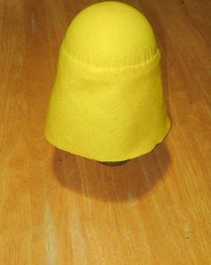 a yellow hat sitting on top of a wooden table