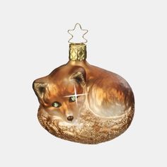 a glass ornament shaped like a fox with a star on its head and eyes