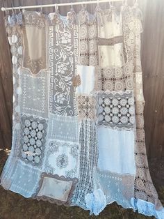 an old curtain is hanging on a clothes line outside in the sun with some lace and crochet