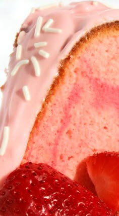 a piece of cake with pink frosting and strawberries