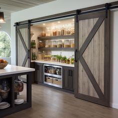 an open kitchen with sliding doors leading into the pantry