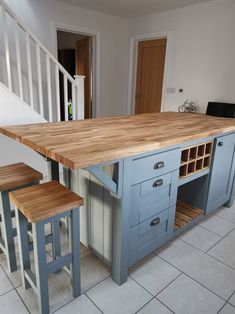 a kitchen island with two stools in front of it and an open drawer under the counter