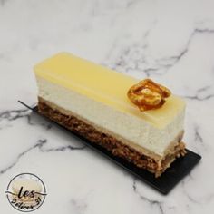 a piece of cheesecake on a marble counter top with a gold leaf decoration in the middle