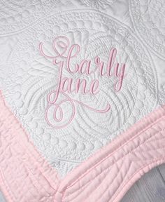 a pink and white quilted blanket with the word fearless jane written on it in cursive font