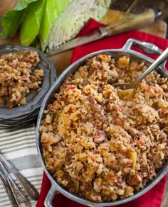 a pot filled with food sitting on top of a table next to a knife and fork