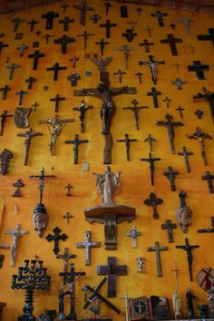 the wall is covered with crosses and crucifixs