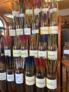 there are many different types of incenses in the glass jars with labels on them