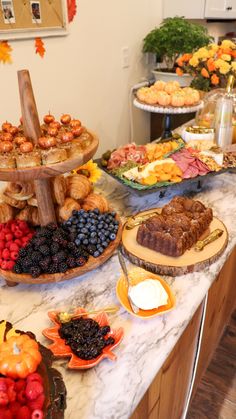 a table filled with lots of food on top of a white marble counter topped with fruit