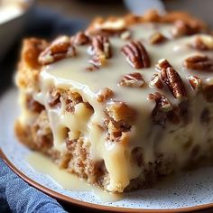 a close up of a piece of cake on a plate with pecans in the background