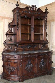 an old fashioned wooden cabinet with carvings on the front and side doors, in a room