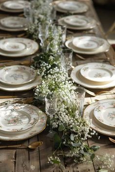 a long table with plates and flowers on it