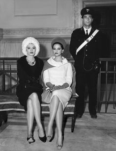 an old black and white photo of two women sitting on a bench next to a man in uniform