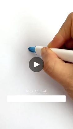 a person is writing on a piece of paper with a white marker and blue tip