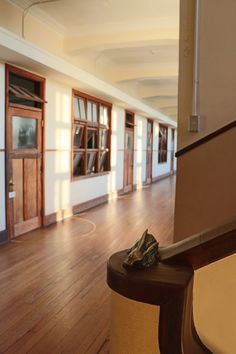 a pair of shoes sitting on top of a wooden floor in an empty room with lots of windows