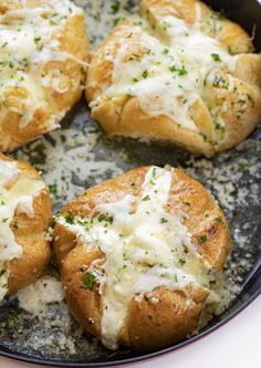 baked breads with cheese and herbs in a skillet on a white counter top