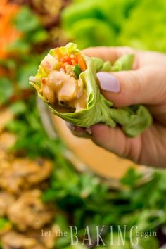 a person is holding up some food in their hand and it looks like they are eating lettuce