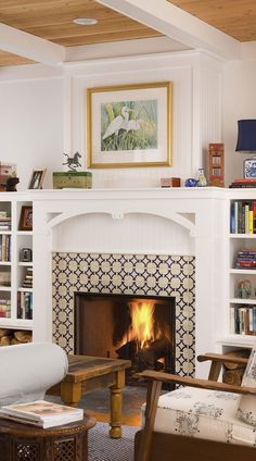 a fireplace with bookshelves and a painting above it