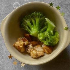 broccoli and mushrooms in a white bowl on a table with stars around it