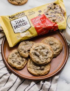 cookies and milk are on a plate next to a bag of toll house