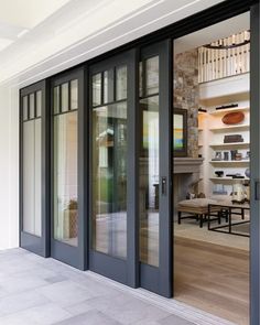 an open door leading to a living room and dining area with glass doors on both sides