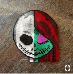 a piece of art made to look like a skull with red hair and green eyes