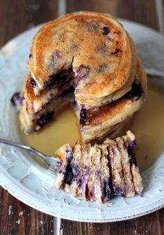 a stack of blueberry pancakes on a plate with syrup