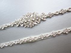 "This elegant bridal belt is made with the finest Swarovski crystals and it is fitted to your measurements. The belt measures 3/8\" wide and the center detail measures 1 1/4\" tall and 3\" long. The belt is beaded on a sheer organza ribbon. The organza ribbon is available in white, off white or ivory color. The metal settings finish is available in gold, silver or rose gold finish. - This belt is fitted and it is finished with the hook and eye closure - Shown in the photos in the finish combinat Elegant Silver Belt With Rhinestones, Formal Adjustable Bridal Belt With Rhinestones, Formal Adjustable Rhinestone Bridal Belt, Elegant White Belt With Rhinestones, Adjustable Silver Bridal Belt For Formal Occasions, Silver Adjustable Bridal Belt For Formal Occasions, Formal Adjustable Bridal Belt With Sashes, Formal Silver Adjustable Bridal Belt, Elegant Rhinestone Belts For Formal Occasions