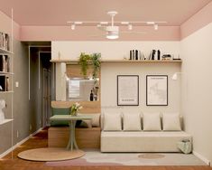 a living room filled with furniture and bookshelves next to a table on top of a hard wood floor