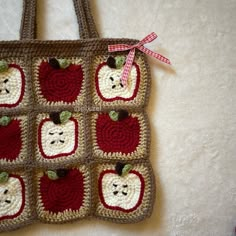 a crocheted bag with apples and bears on it