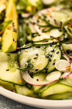 a white plate topped with cucumbers and onions