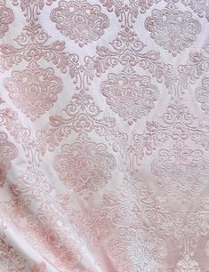 the fabric is pink and white with an intricate design on it's side,