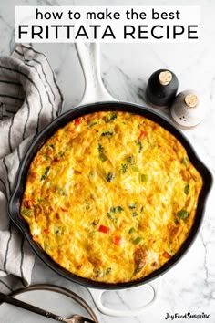 an omelet in a cast iron skillet on a marble countertop next to utensils