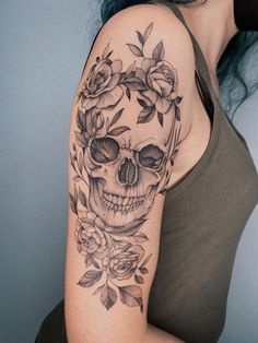 a woman with a skull and roses tattoo on her arm