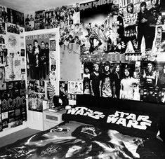 black and white photograph of a bedroom with star wars pictures on the wall, bedding and posters