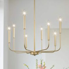 a large chandelier with candles hanging from it's centerpiece in a dining room