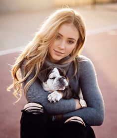 a woman holding a small dog in her arms