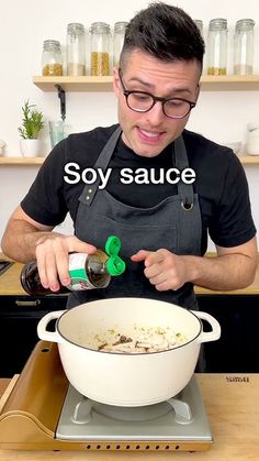 a man pouring sauce into a large white pot on top of a kitchen stove with the words soy sauce above it