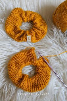 two yellow knitted scrunffs sitting on top of a white fur covered floor