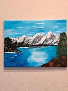 a painting on the wall of a house with mountains in the background and blue water