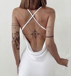 the back of a woman's body with tattoos on her upper and lower half