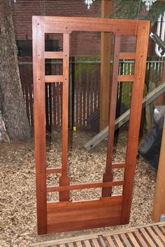 a wooden frame sitting next to a tree