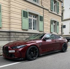 a red sports car parked on the side of the road in front of a building