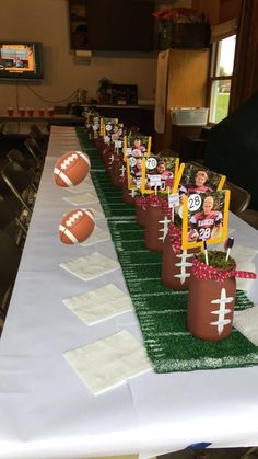 football themed centerpieces are lined up on a table at a sports game party