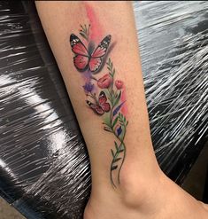 a woman's foot with flowers and butterflies on the top part of her leg