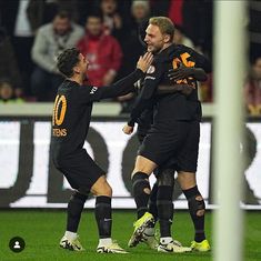 two soccer players are congratulating each other on the field