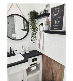 a white bathroom with black counter tops and shelves on the wall, along with a mirror