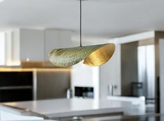 a modern kitchen with an island and white counter tops in the background, along with two hanging pendant lights