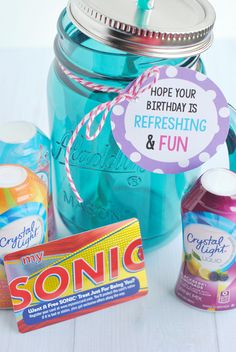 a mason jar filled with candy and personalized birthday tags for someone's birthday